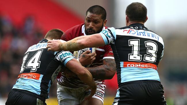 Wigan’s Frank-Paul Nuuausala runs at Cronulla’s Jayden Brailey and Paul Gallen.