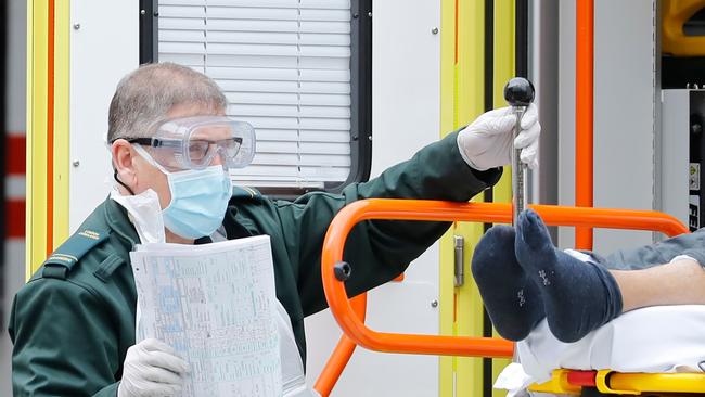 A member of the ambulance services assists in moving a patient from an ambulance to St Thomas' Hospital in London. Picture: AFP.