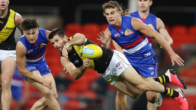 Tigers defender Trent Cotchin gets flying handball away against the Bulldogs Picture: Michael Klein