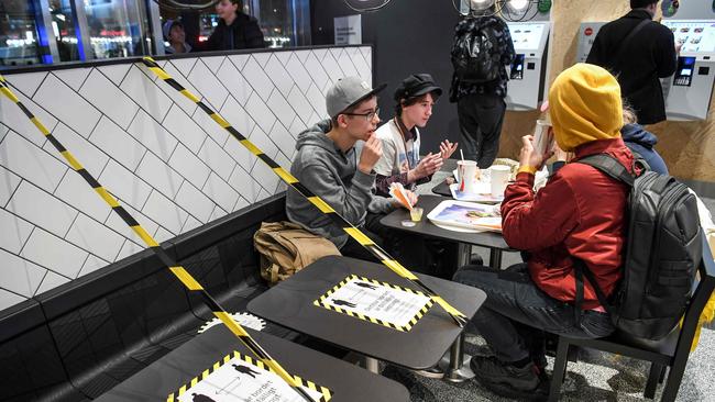 Guests at a fast food restaurant next to taped off tables in central Stockholm. Picture: AFP