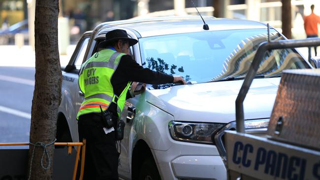 A ranger issues a fine in Sydney CBD. Picture: Christian Gilles