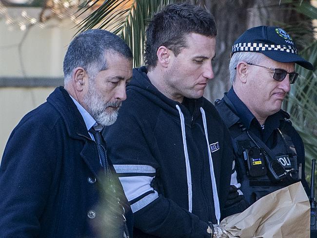 The 33-year-old man that lived at the house has been handcuffed and led away by police. Picture: Mark Brake