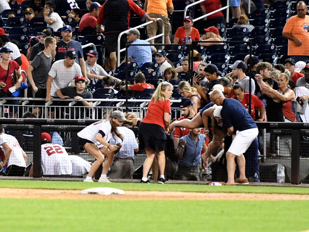 Fans run for cover after shots were heard during the baseball game.