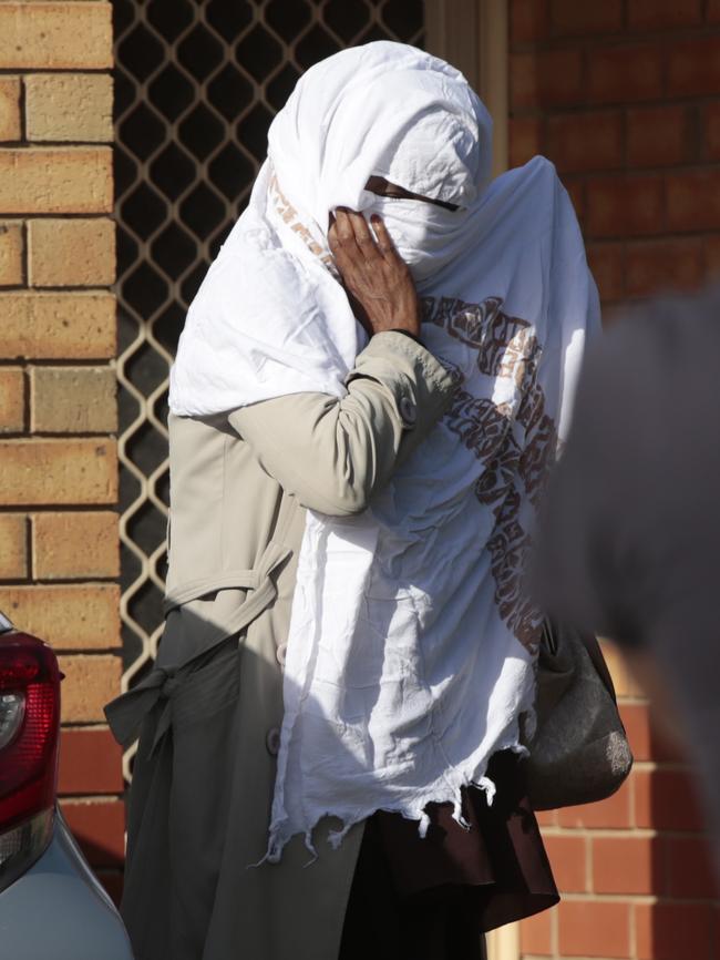 A woman leaves the Adelaide address of an an African-born South Australian woman, who is facing a terrorism charges. Picture: Tait schmaal