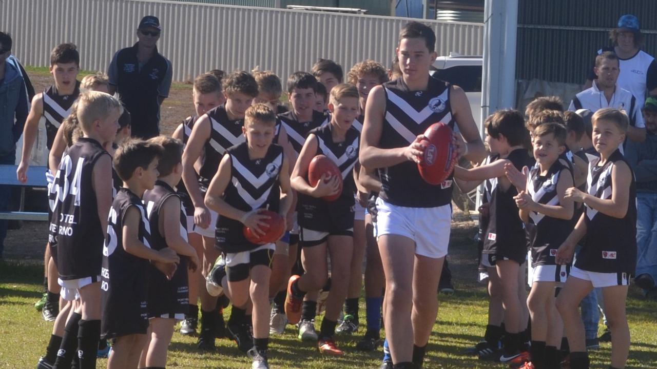 SA Little Legend Cooper Llewelyn, 15, Port Magpies Football Club, has played a milestone 100 games with his beloved club while still a junior. Cooper is pictured here leading the Colts team onto the ground as the junior Colts form a guard of honour for him. Picture supplied.