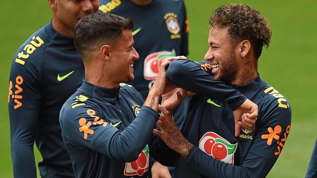 Brazil's midfielder Philippe Coutinho (L) and Brazil's striker Neymar share a joke