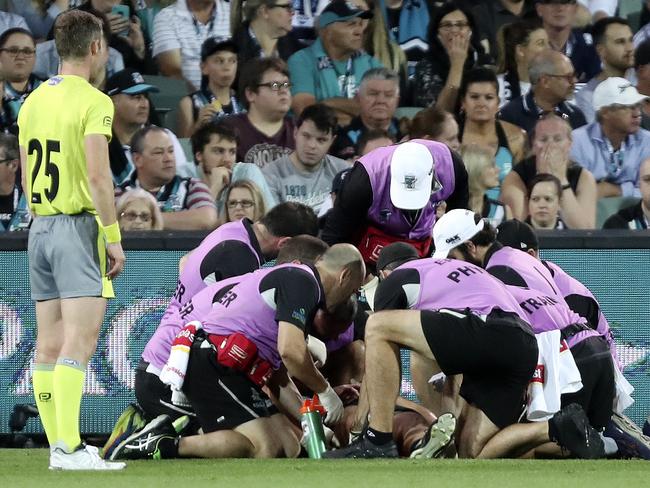 Hamish Hartlett being attended to after cutting his head in a clash with Dangerfield.