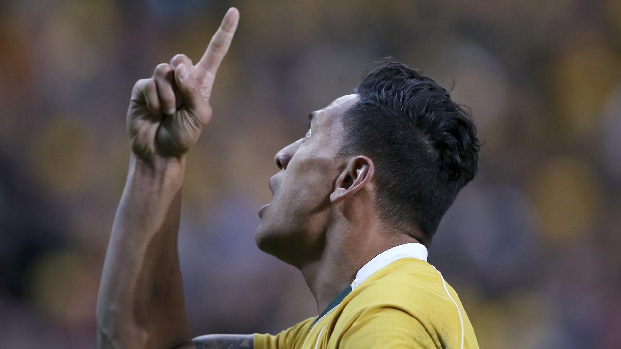 Israel Folau points to the sky after scoring a try against England.