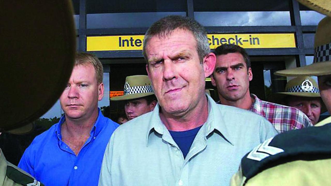 Bradley John Murdoch surrounded by police arrives at Darwin airport from Adelaide November 24 2003. AFP photo/David Hancock