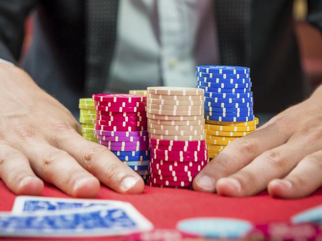 Poker player going "all in" pushing his chips forward