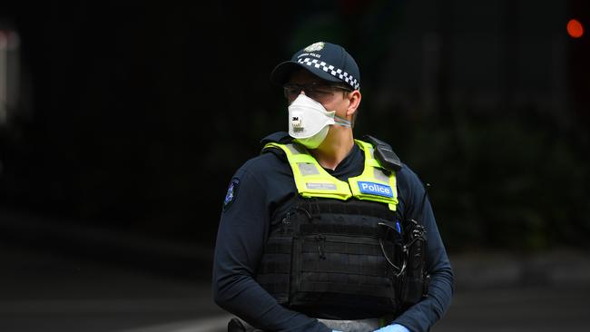 A Victoria Police officer wearing a face mask outside Crown Metropol Hotel during the early phase of hotel quarantine. Victoria Poice has renewed Unified Security’s licence. Picture: AAP