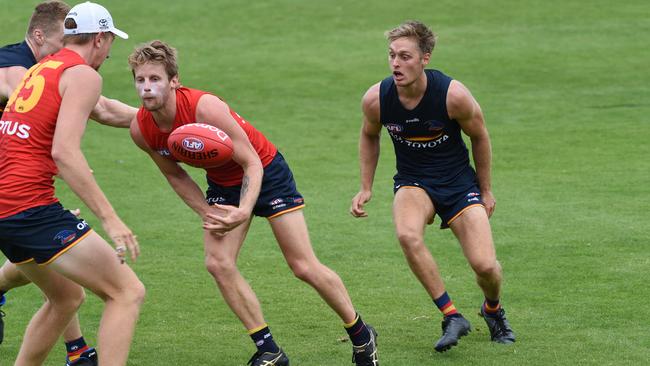 Rory Sloane handballs with Jackson Hately in hot pursuit.