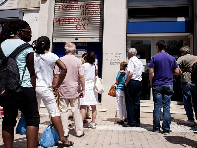 Getting all they can ... People queue at a bank ATM in Athens. Picture: AFP/IAKOVOS HATZISTAVROU