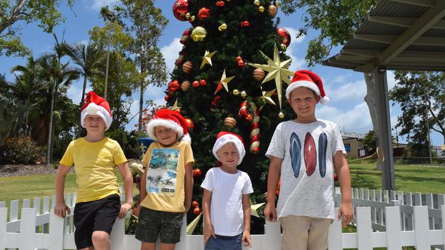 Billy, Oliver and Henry Dent and Cooper Monkman in front of the Christmas tree at the Airlie Beach Foreshore. Picture: Jordan Gilliland