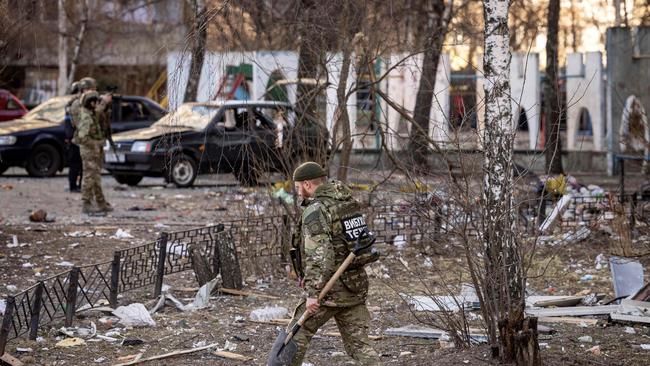 A member of the Ukrainian Territorial Defence Forces walks near a residential building which was hit by the debris from a downed rocket, in Kyiv. Picture: AFP