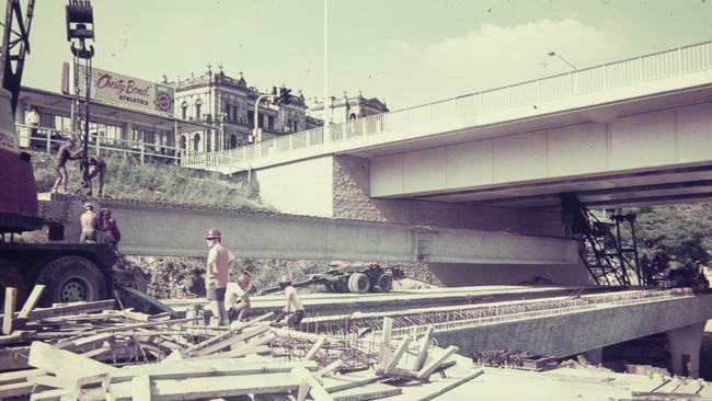 Workers and a crane installing a very large concrete beam during construction of the Riverside Expressway, Brisbane. Photo: Gordon Foot/State Library of Queensland