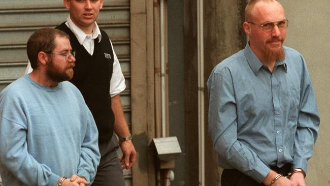 Serial killers John Justin Bunting, left, and Robert Joe Wagner, right – pictured with a guard, centre – are serving life sentences without parole. Picture: Campbell Brodie