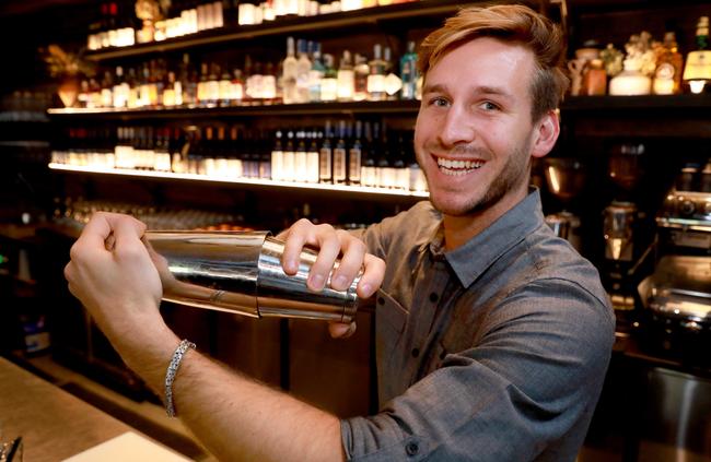 Luca serves up a cocktail at the bar, where patrons can sit and enjoy bar snacks and drinks.