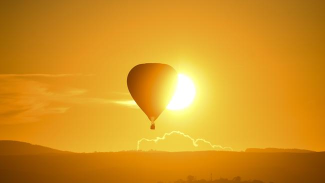 A hot-air balloon rising over Lake Burley-Griffin in Canberra. Picture: AAP Image/Lukas Coch