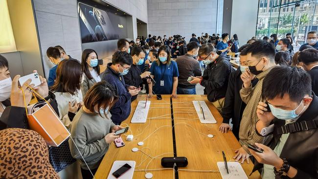 People try out the new iPhone 12 mobile phones at an Apple store in Shanghai. Picture: AFP