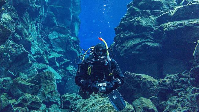 A scuba diver in the middle of a divergent plate boundary.