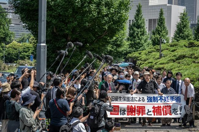 Lawyers and supporters of victims of forced sterilisation under a now-defunct eugenics law, carrying a banner demanding apologies and compensations, march toward the Supreme Court of Japan in Tokyo