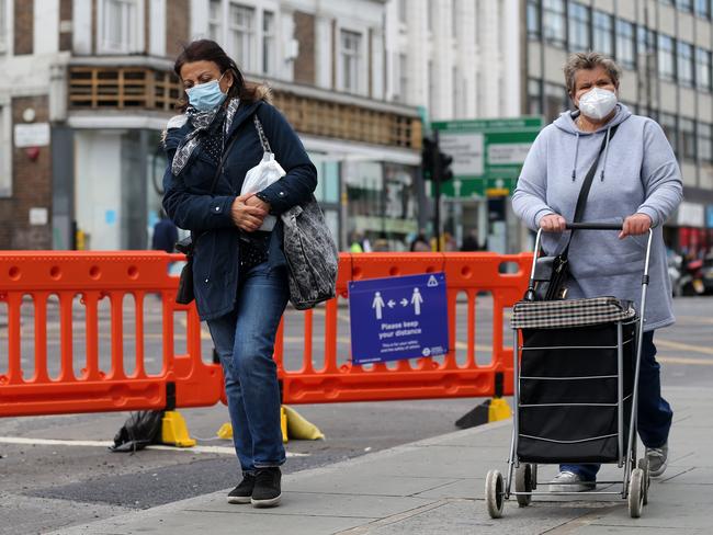 Women wear face masks as they walk down Camden High Street in central London. Picture: AFP