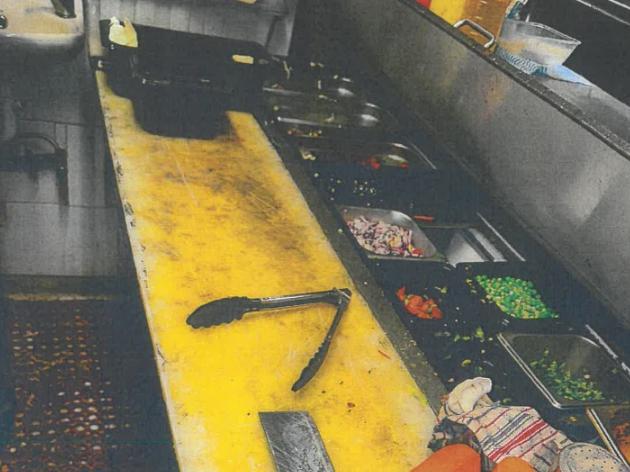 Grotty food preparation area and badly stained benchtop chopping board.