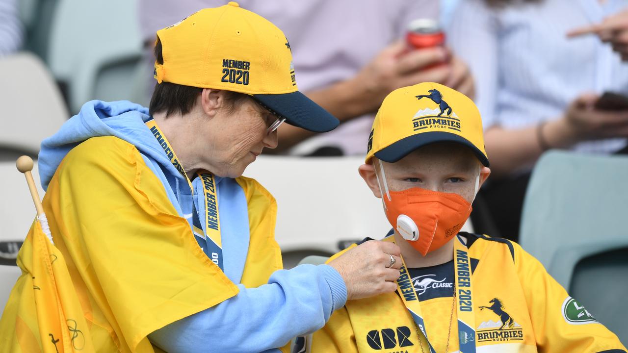 A young Brumbies fan wears a face mask at GIO Stadium in Canberra.