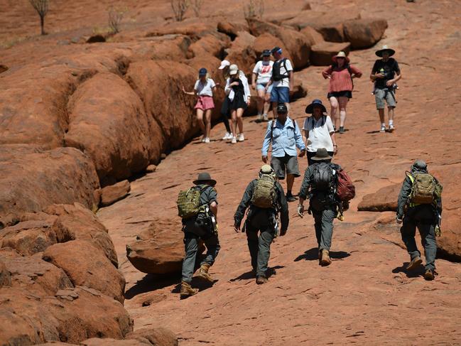 Tourists climb the Uluru, also known as Ayers Rock, on a sunny day at Uluru-Kata Tjuta National Park in Australia's Northern Territory Friday. Picture: AAP