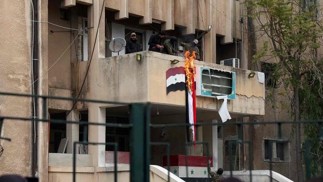 Anti government forces set the Syrian flag on fire in the city of Salamiyah in the central Hama governorate, on December 7, 2024. Picture: Omar Haj Kadour/AFP