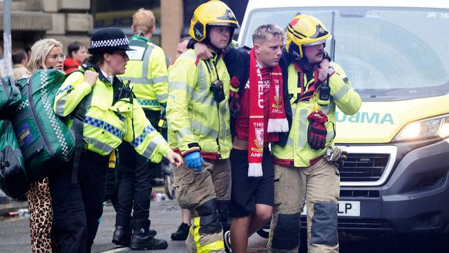 Police and emergency personnel help a man injured in the incident. Picture: AP