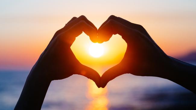 ESCAPE: Romance, Paul Ewart -  hands forming a heart shape with sunset silhouette. Copy space text. . Picture: iStock