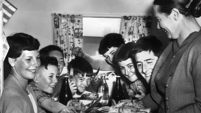 Christmas in Australia takes many forms. For the Taylor family on holiday by the sea at Torquay on December 25, 1956, Christmas dinner was roast chicken a la caravan. Photo: Frank Grant/The Argus Image from HWT book 'MOMENTS IN TIME'.