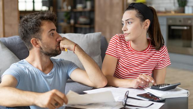 Frustrated concerned young couple calculating overspend budget, doing paperwork job at laptop, talking about financial problems, insurance, mortgage, fees, loan conditions, bankruptcy, economic inflation; money budgeting stress banking generic