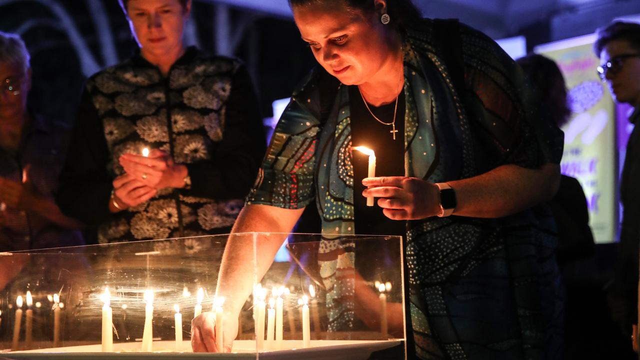 Natalie Colburn lights a candle during the Brisbane Domestic Violence Service candlelight vigil from Roma Street Parklands. Picture: Zak Simmonds