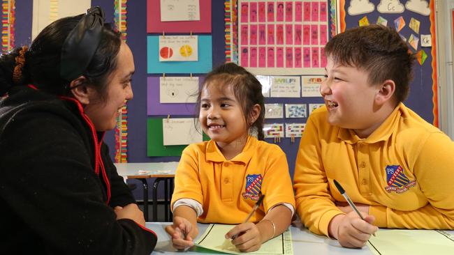 YMCA’s Ata Rameka helps students Hayley Vu and Leo Grijak write letters to their pen pals. Picture: Robert Pozo