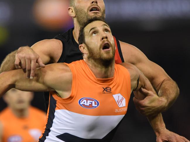 Shane Mumford of the Giants (front) and Tom Bellchambers of the Bombers contest during the Round 15 AFL match between the Essendon Bombers and the GWS Giants at Marvel Stadium in Melbourne, Thursday, June 27, 2019. (AAP Image/Julian Smith) NO ARCHIVING, EDITORIAL USE ONLY