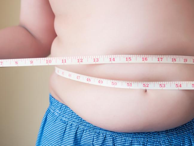 A generic stock image showing an obese or overweight child measuring his weight isolated on white background. Picture: istock