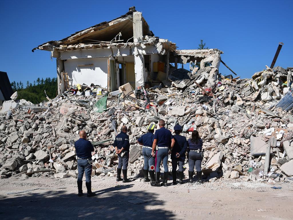 AMATRICE, ITALY - AUGUST 25: Police officers view the remains of a building that was destroyed during an earthquake, on August 25, 2016 in Amatrice, Italy. The death toll in the 6.2 magnitude earthquake that struck around the Umbria region of Italy in the early hours of Wednesday morning has risen to at least 247 as thousands of rescuers continue to search for survivors. (Photo by Carl Court/Getty Images)