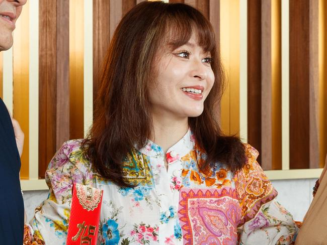 DAILY TELEGRAPH. Chinese parents visiting their ex-pat children to buy them a house as a lunar new year gift. Pictured is Kira Lee with her parents in the lobby of her apartment in Wentworth Point, holding RednoteÃ•s - traditional gift envelopes. Friday 24/01/2025. Picture by Max Mason-Hubers