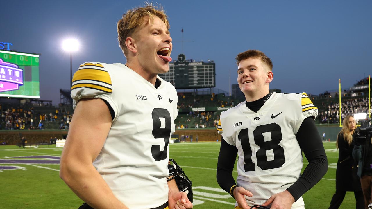 CHICAGO, ILLINOIS - NOVEMBER 04: Tory Taylor #9 and Drew Stevens #18 of the Iowa Hawkeyes celebrate after defeating the Northwestern Wildcats at Wrigley Field on November 04, 2023 in Chicago, Illinois. (Photo by Michael Reaves/Getty Images)