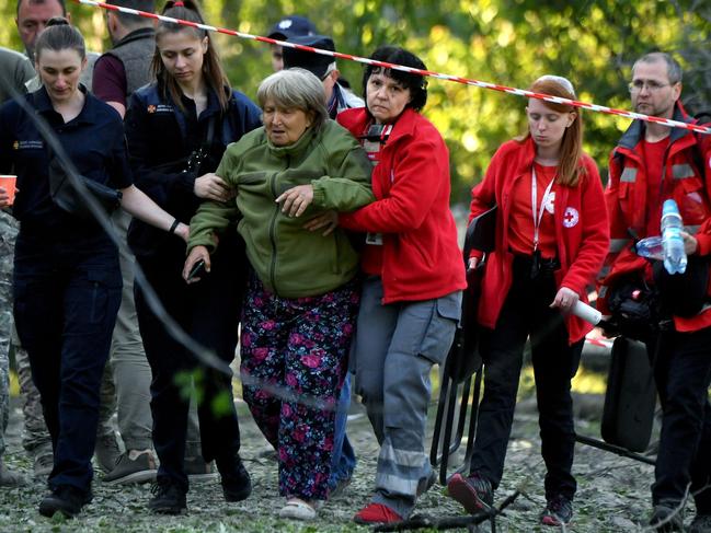 Rescuers and medical workers assist a woman whose daughter and granddaughter died as a result of a downed missile explosion during the Russian attack on Kyiv. Picture: AFP