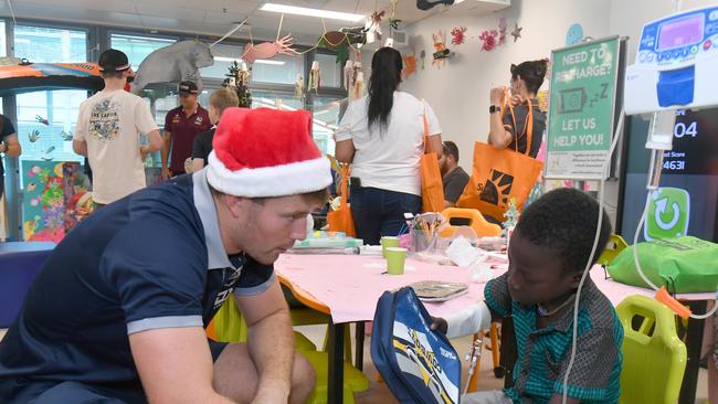 Cowboys Harrison Edwards paid a surprise visit to patients, including Koumbal Mahamal, 8, at the Childrens' Ward at the Townsville University Hospital. Picture: Evan Morgan