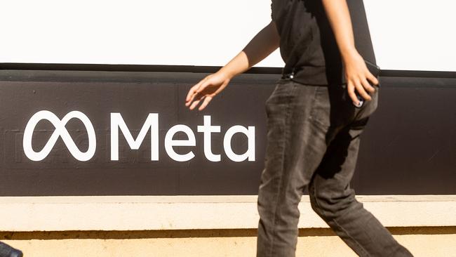 (FILES) A person walks past a newly unveiled logo for 