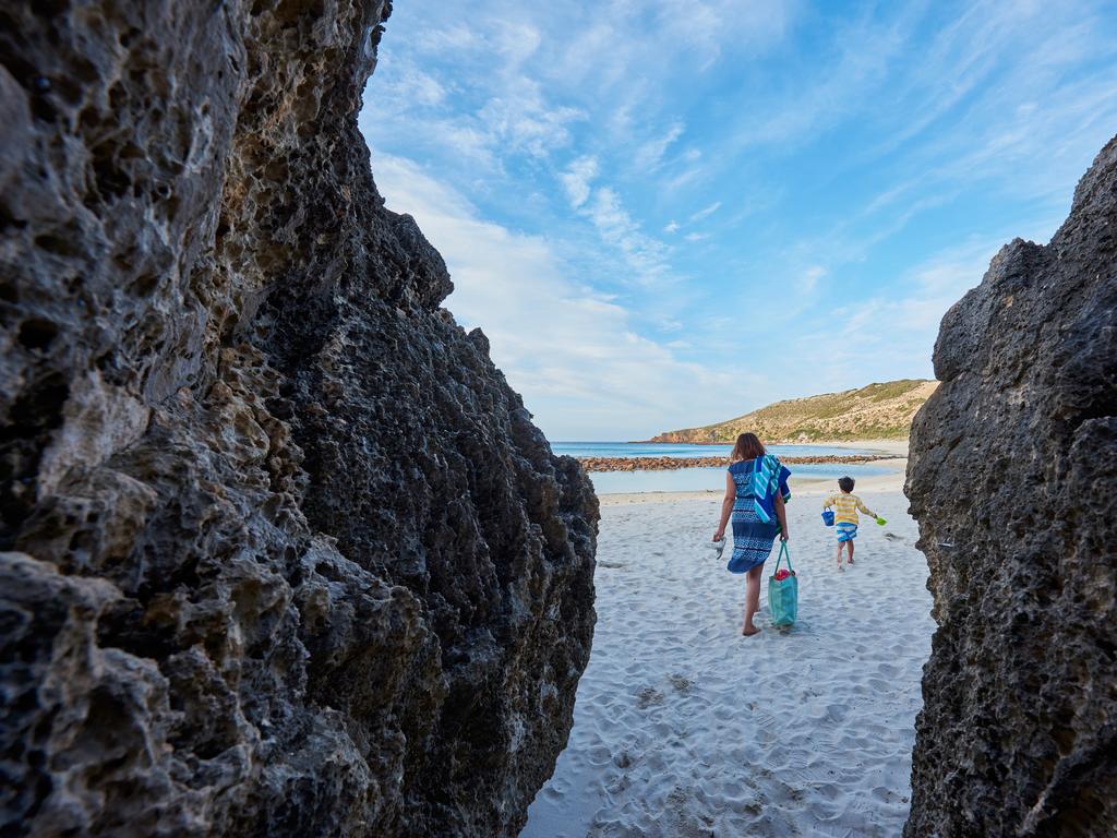 <b>STOKES BAY BEACH, KANGAROO ISLAND, SOUTH AUSTRALIA:</b> The hidden beach at Stokes Bay on Kangaroo Island’s north coast emerges beyond a short, cave-like walking track. Visitors step out from the tunnel to discover a sandy beach, a calm inlet with clear water and a huge natural rock pool to shelter swimmers from the waves. Tourism Australia ranks it as among the nation’s top swimming beaches. Kids love exploring rock pools at the water’s edge and the bay area is also popular with the island’s most famous residents - kangaroos. <a href="http://www.kangarooisland-australia.com/" target="_blank">kangarooisland-australia.com</a> Picture: SATC