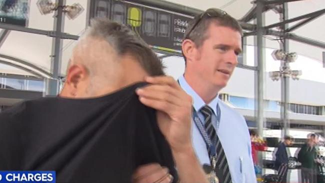 Tomas Novak covers his face at the Gold Coast Airport in 2017. Picture: Nine News