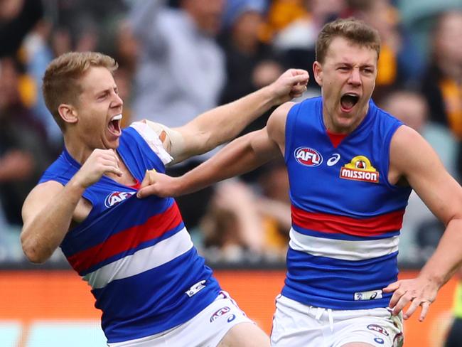 MELBOURNE, AUSTRALIA - MARCH 31: Jack Macrae of the Bulldogs celebrates after kicking a goal with Lachie Hunter of the Bulldogs during the round two AFL match between the Hawthorn hawks and the Western Bulldogs at Melbourne Cricket Ground on March 31, 2019 in Melbourne, Australia. (Photo by Scott Barbour/AFL Photos/Getty Images)