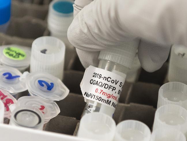 (FILES) In this file photo Dr. Nita Patel, Director of Antibody discovery and Vaccine development, lifts a vial with a potential coronavirus, COVID-19, vaccine at Novavax labs in Rockville, Maryland on March 20, 2020, one of the labs developing a vaccine for the coronavirus, COVID-19. - US authorities warned healthcare and scientific researchers May 13, 2020 that Chinese-backed hackers were attempting to steal research and intellectual property related to treatments and vaccines for COVID-19. Organizations researching the disease were warned of "likely targeting and network compromise by the People's Republic of China," a statement from the FBI and the Cybersecurity and Infrastructure Security Agency said."China's efforts to target these sectors pose a significant threat to our nations response to COVID-19," they said. (Photo by ANDREW CABALLERO-REYNOLDS / AFP)