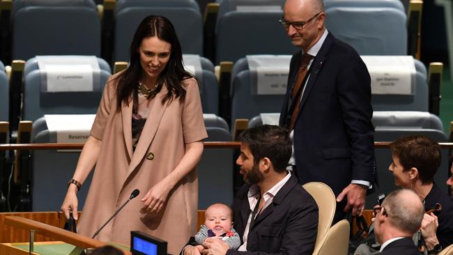 PM Ardern hands over baby Neve duty to husband Clarke Gayford as she heads to the stage to speak at the summit. Picture: Don Emmert/AFP